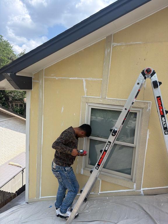 Zooby team member repairing siding around a window on a San Antonio home
