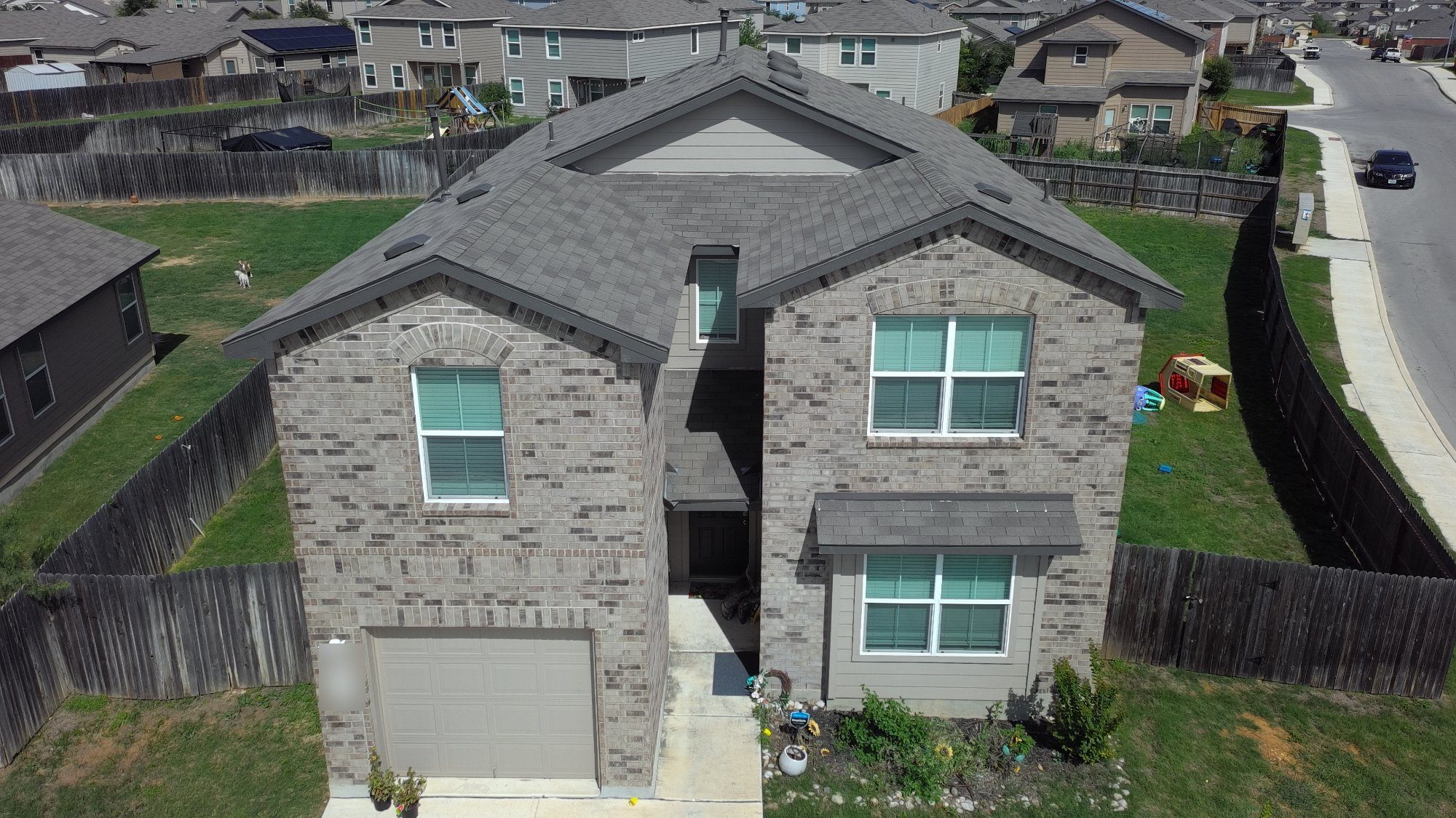 Zooby roof repair on a two-story brick home in San Antonio